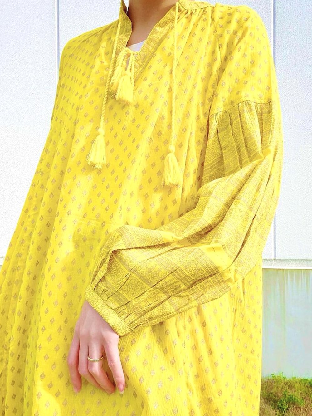 イエロー系のワンピース、パープル系のスカート、グレー系のスニーカーを着用したレディースの春コーディネートの3枚目の写真