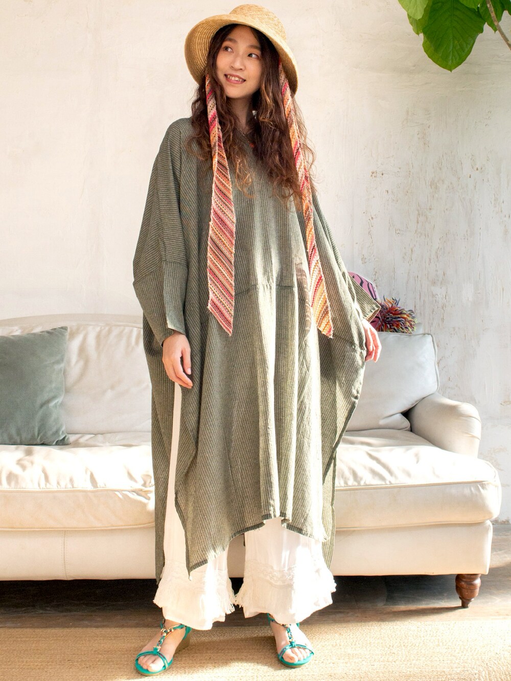 グリーン系のワンピース、ブルー系のサンダル、ベージュ系のハットを着用したレディースの春コーディネートの4枚目の写真