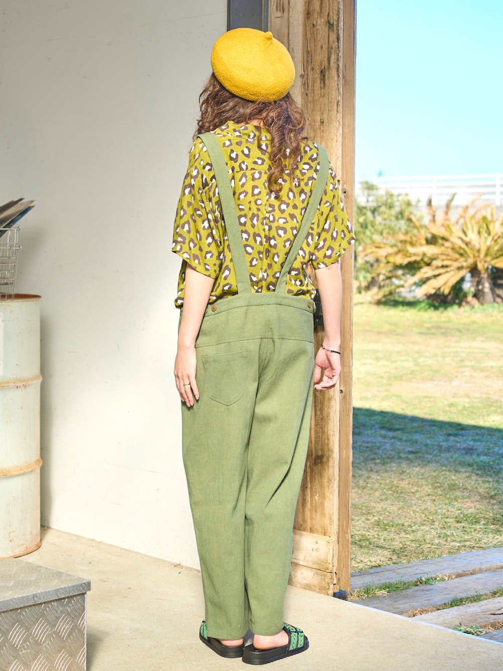 グリーン系のサロペット/オーバーオール、グリーン系のシャツ/ブラウス、ブラック系のサンダルを着用したレディースの夏コーディネートの2枚目の写真