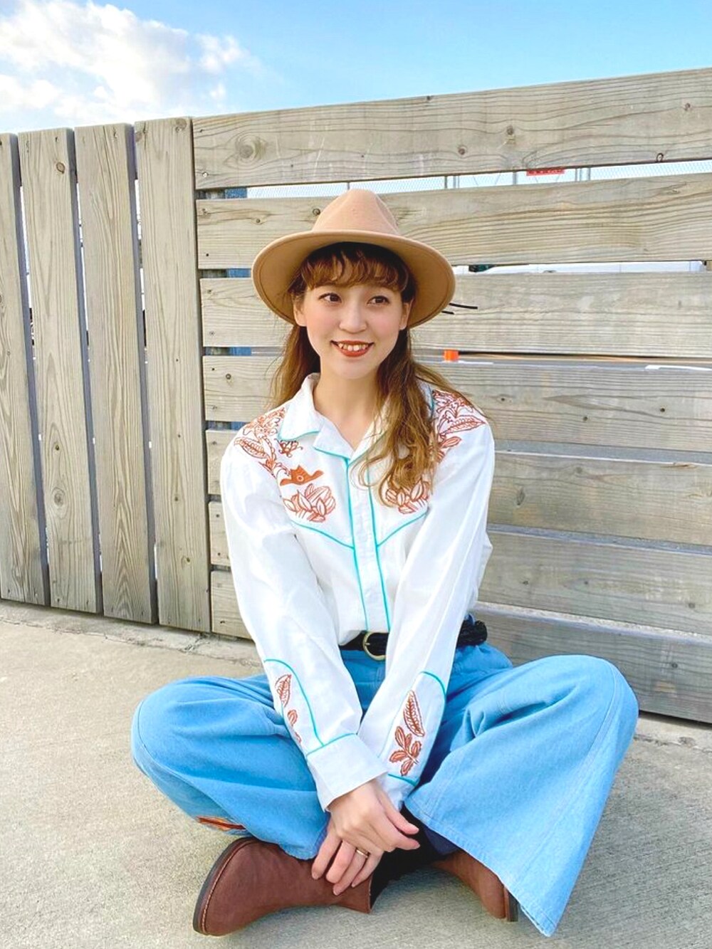 ホワイト系のシャツ/ブラウス、ブルー系のデニムパンツ、ブラウン系のブーツを着用したレディースの冬コーディネートの2枚目の写真