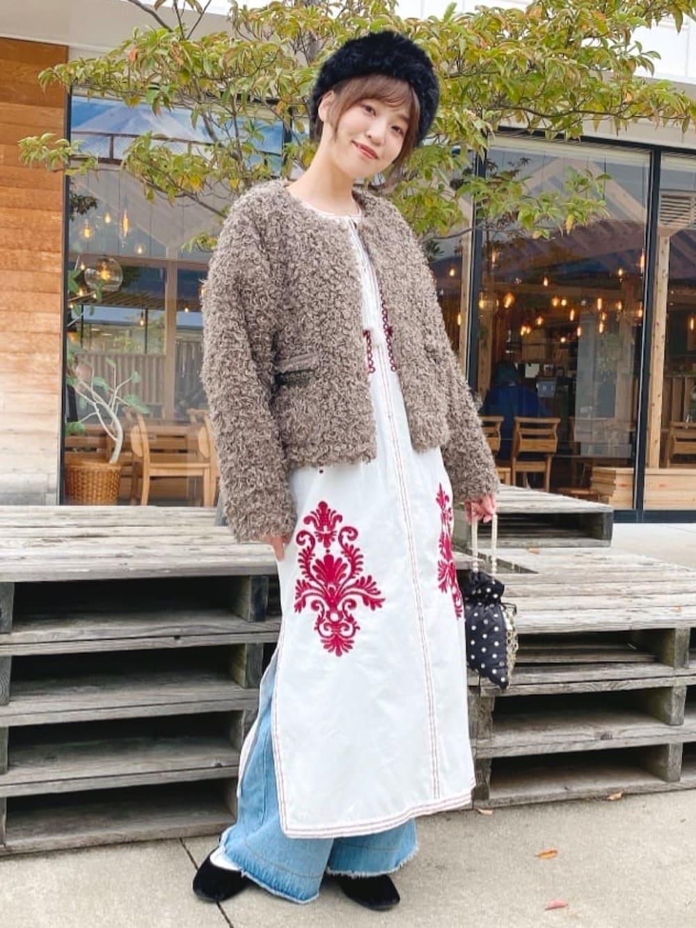 ブラウン系のその他アウター、ホワイト系のワンピース、ブラック系のハンドバッグを着用したレディースの秋コーディネートの2枚目の写真