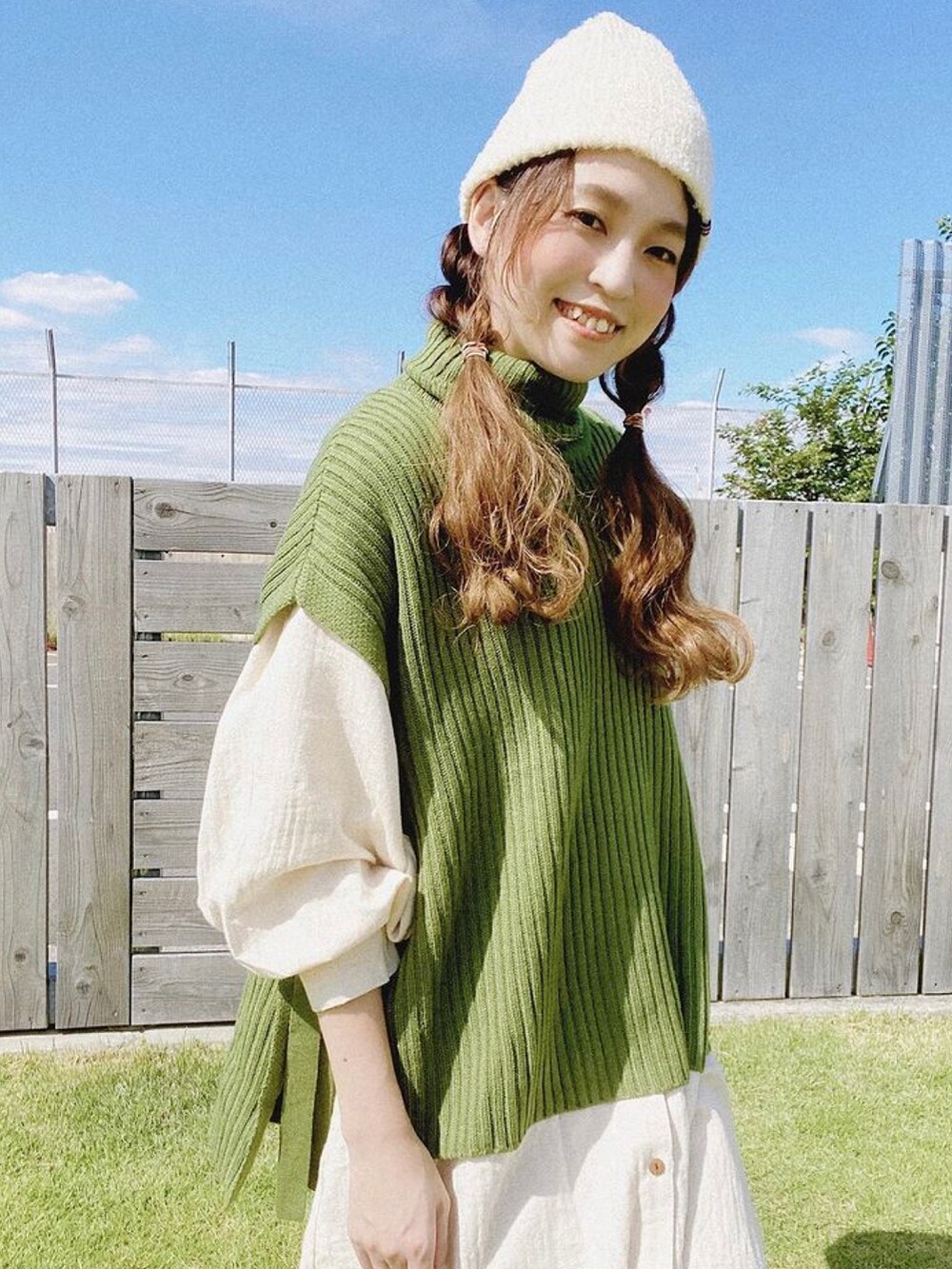 グリーン系のニット/セーター、ホワイト系のシャツワンピース、ベージュ系のその他パンツを着用したレディースの秋コーディネートの3枚目の写真