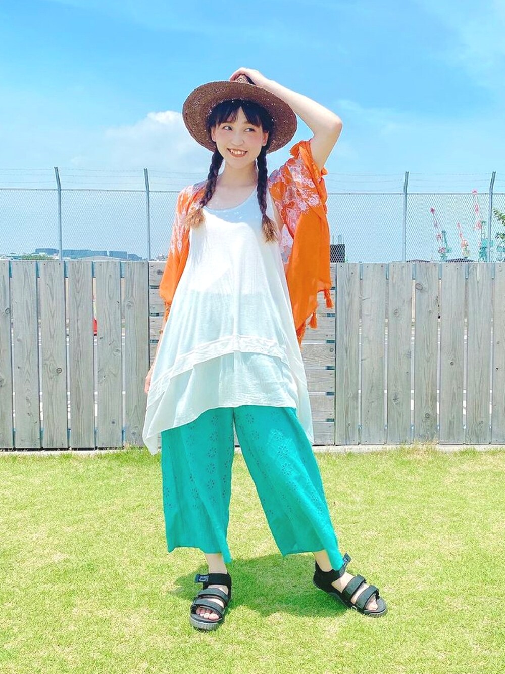 オレンジ系のカーディガン/ボレロ、ホワイト系のタンクトップ、ブルー系のその他パンツを着用したレディースの夏コーディネートの3枚目の写真