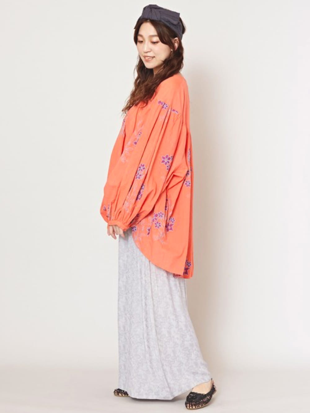 オレンジ系のその他トップス、グレー系のその他パンツ、ブラック系のパンプスを着用したレディースの春コーディネートの2枚目の写真