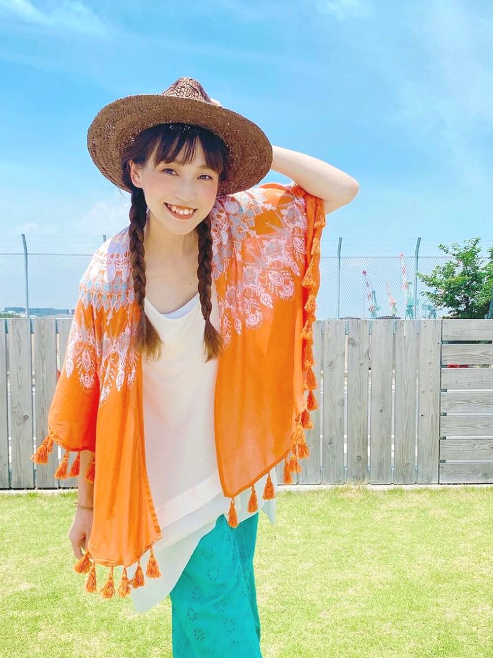 オレンジ系のカーディガン/ボレロ、ホワイト系のタンクトップ、ブルー系のその他パンツを着用したレディースの夏コーディネートの4枚目の写真