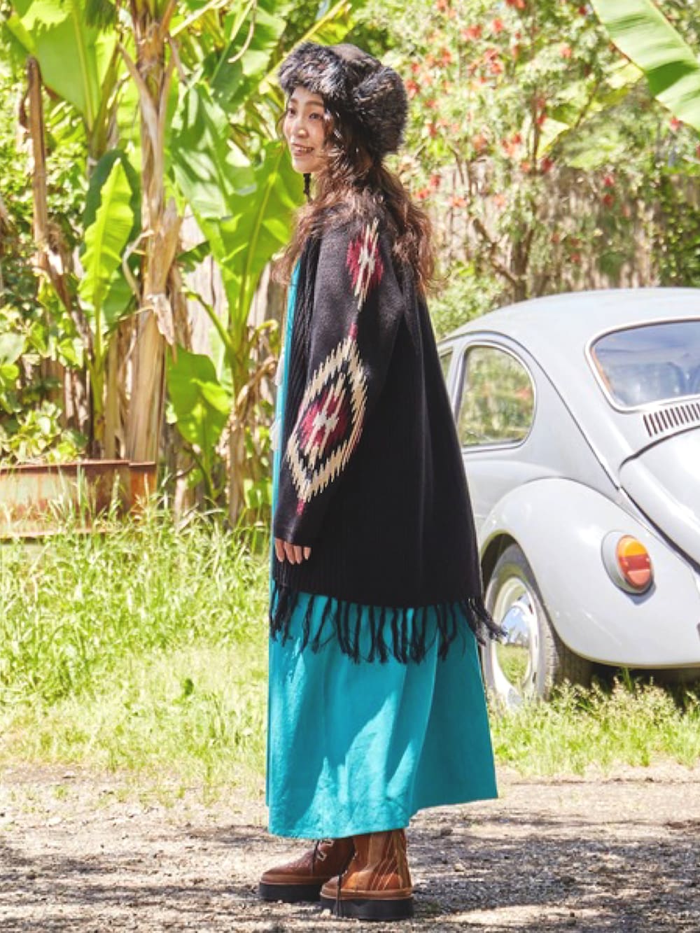 ブラック系のカーディガン/ボレロ、ブルー系のワンピース、ブラウン系のブーツを着用したレディースの秋コーディネートの2枚目の写真