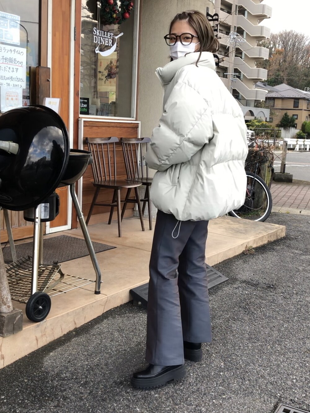 グレー系のパンツ、ブラック系のブーツ、ホワイト系のダウンジャケット/コートを着用したレディースの冬コーディネートの2枚目の写真
