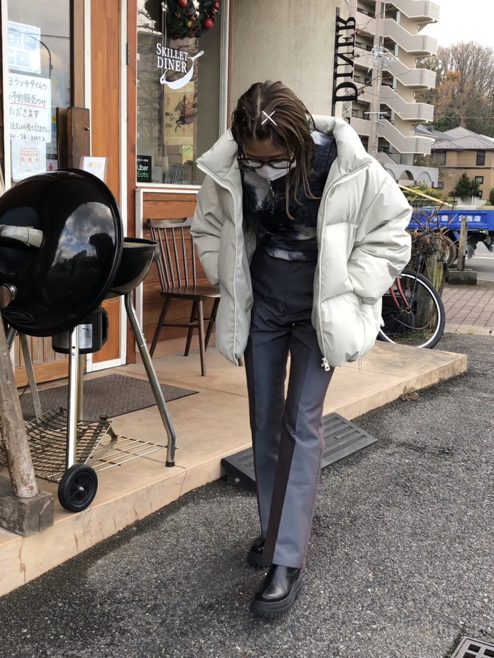 グレー系のパンツ、ブラック系のブーツ、ホワイト系のダウンジャケット/コートを着用したレディースの冬コーディネートの3枚目の写真