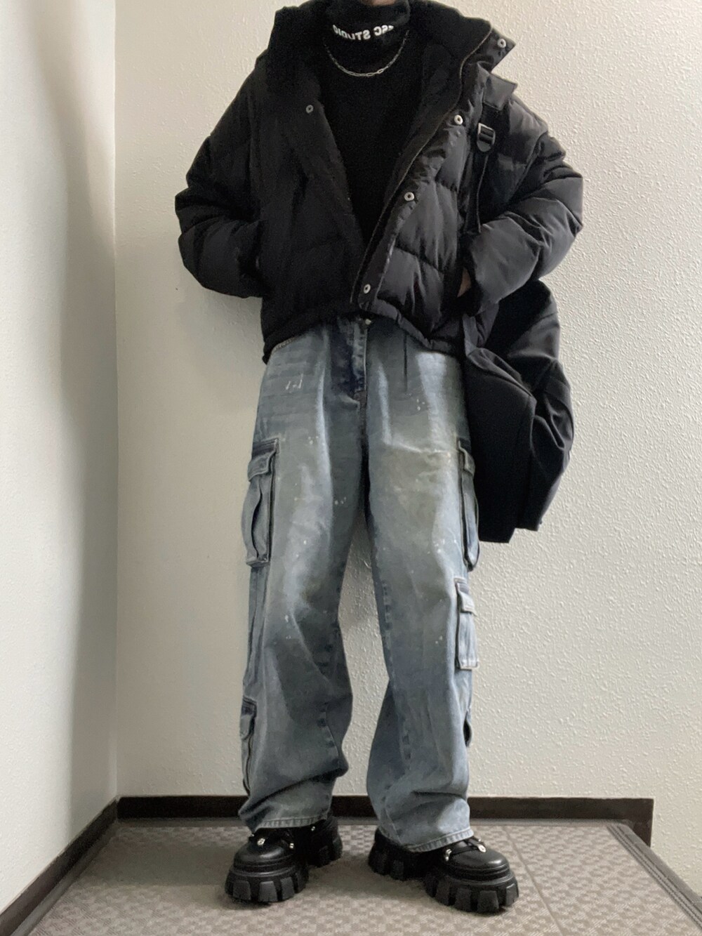 ブラック系のトップス、ブラック系のダウンジャケット/コート、ブラック系のパンツを着用したレディースの春コーディネートの2枚目の写真