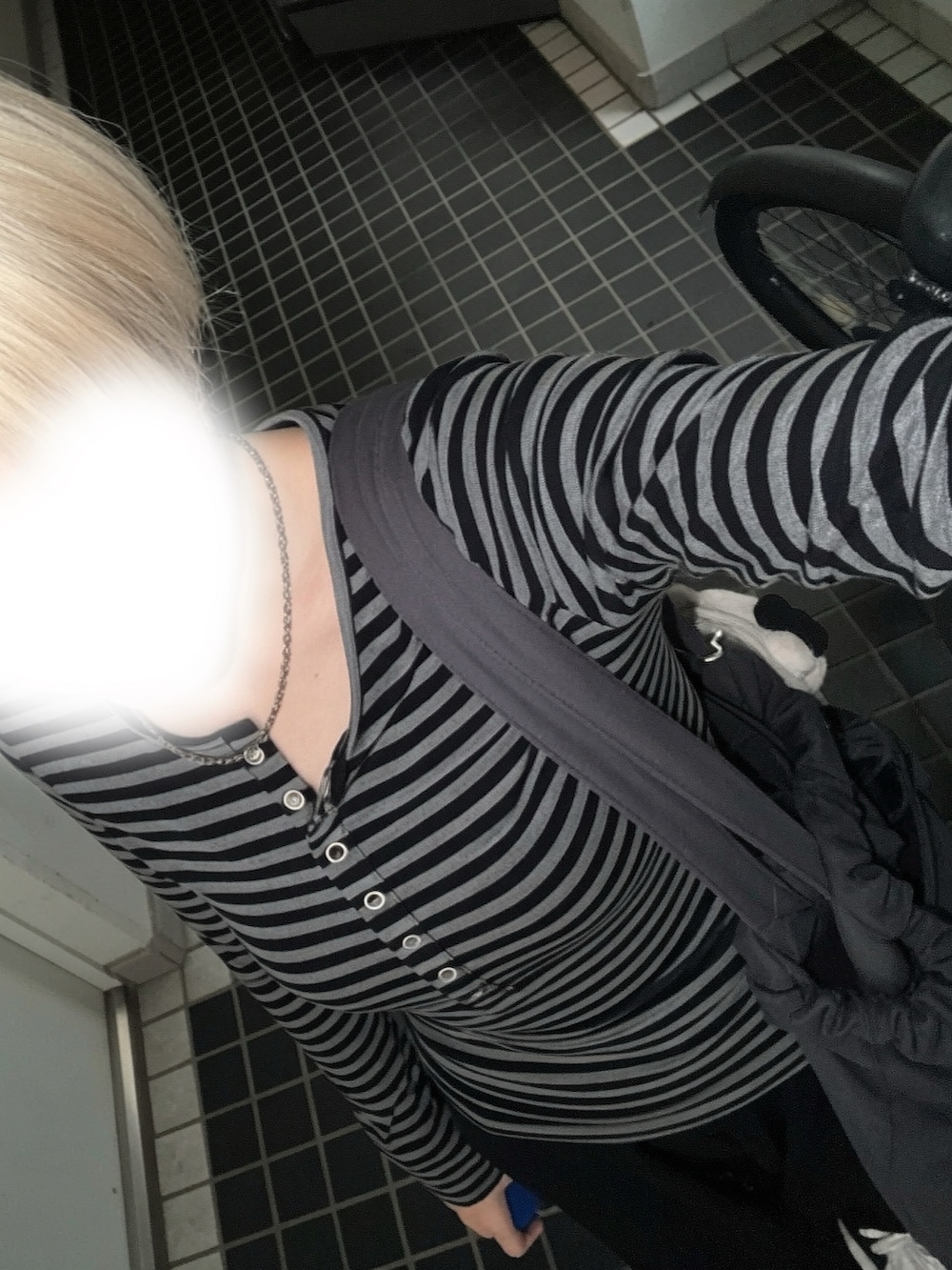 グレー系のタンクトップ、ブラック系のスウェットパンツ、ブラック系のスニーカーを着用したレディースの秋コーディネートの2枚目の写真
