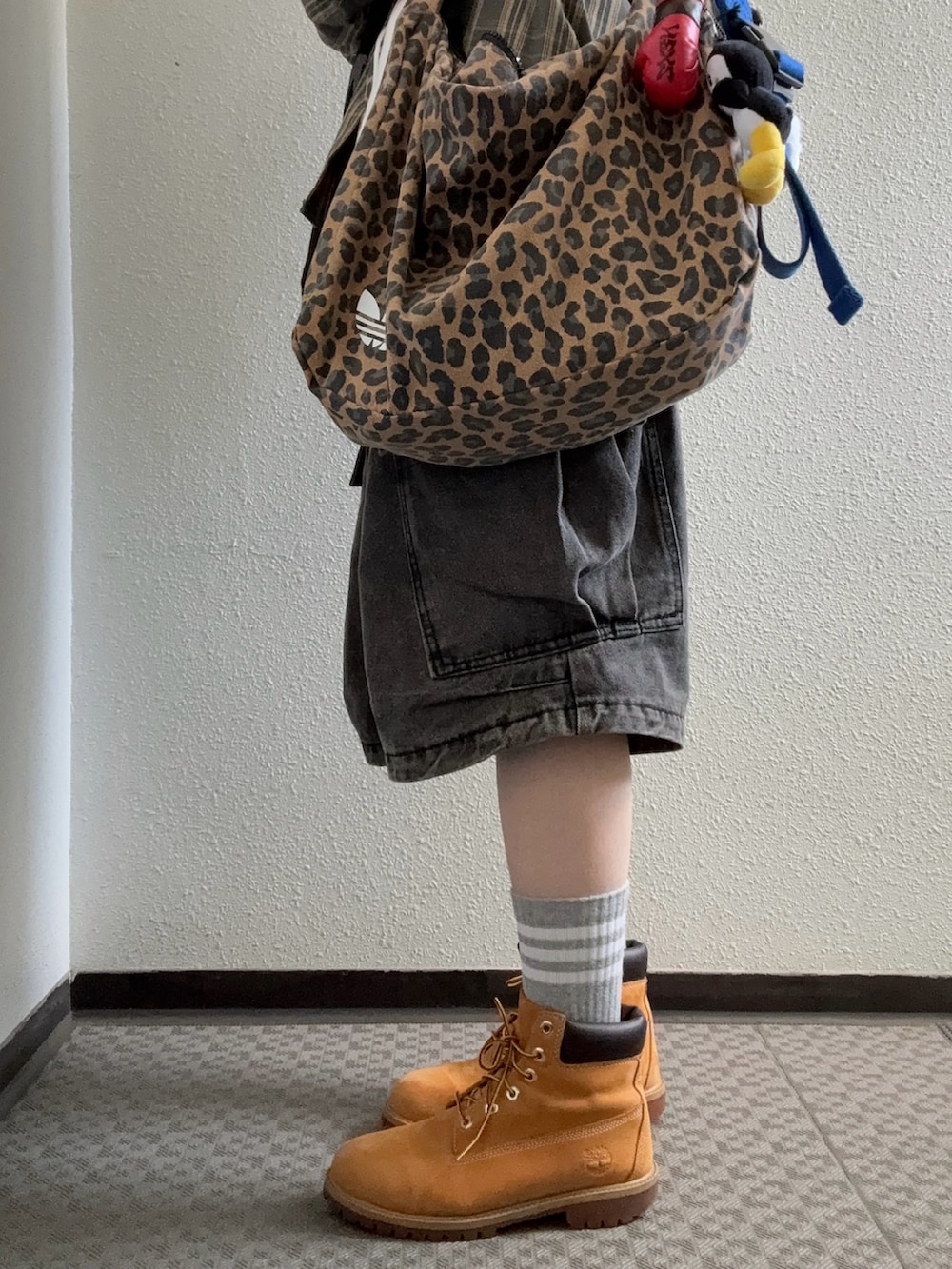 ブラック系のパーカー、ブラウン系のショルダーバッグ、ブラック系のカーゴパンツを着用したレディースの冬コーディネートの2枚目の写真