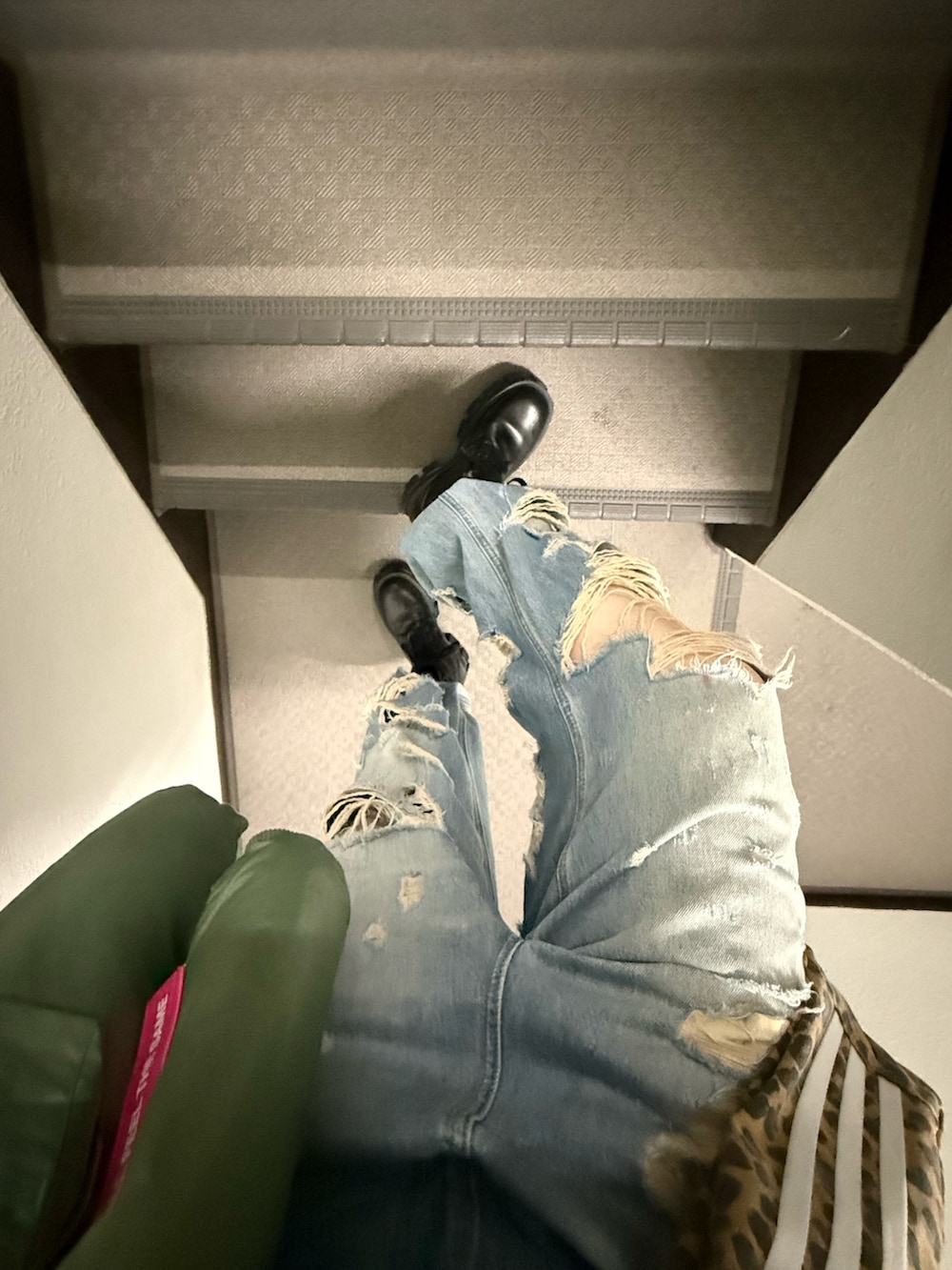 ブルー系のデニムパンツ、ブラウン系のショルダーバッグ、グレー系のトップスを着用したレディースの冬コーディネートの2枚目の写真