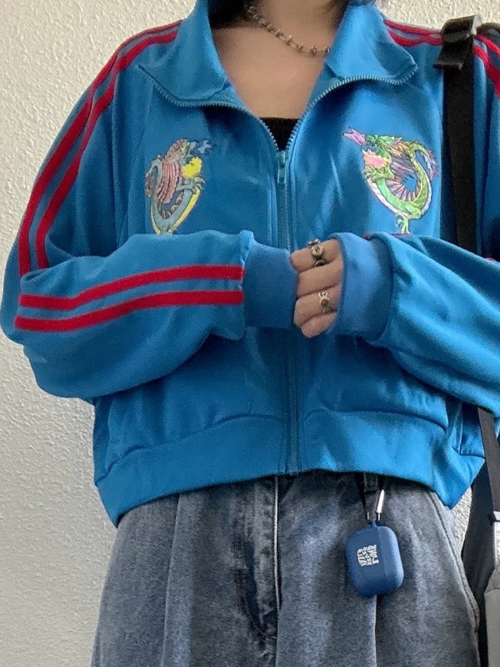 ブルー系のジャージ、ブルー系のデニムパンツ、ホワイト系のシューズを着用したレディースの秋コーディネートの2枚目の写真