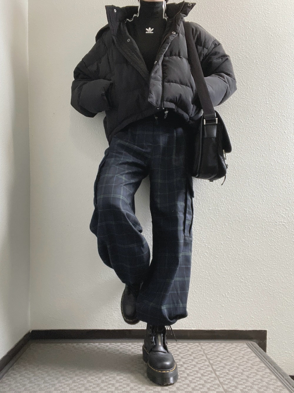 ブラック系のTシャツ/カットソー、ブラック系のダウンジャケット/コート、ブルー系のカーゴパンツを着用したレディースの冬コーディネートの2枚目の写真