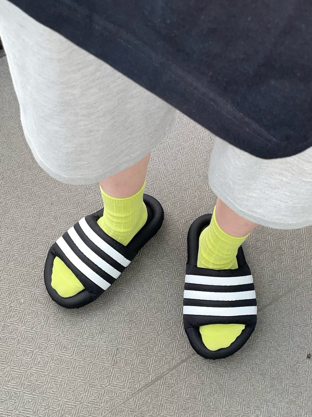 ブラック系のTシャツ/カットソー、グレー系のパンツ、ブラック系のサンダルを着用したレディースの秋コーディネートの3枚目の写真