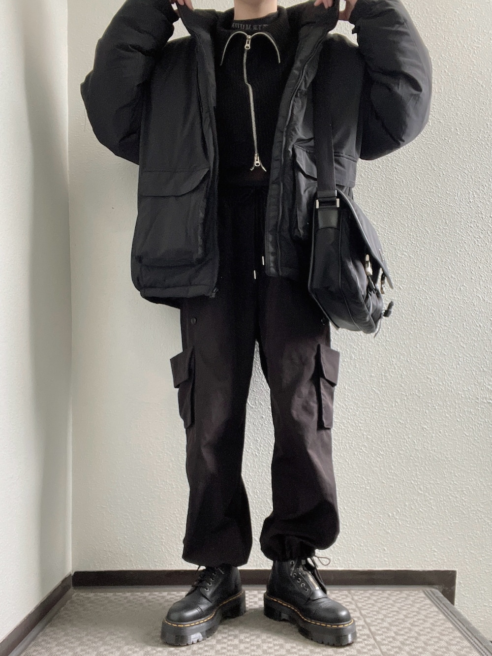 ブラック系のTシャツ/カットソー、ブラック系のニット/セーター、ブラック系のカーゴパンツを着用したレディースの冬コーディネートの2枚目の写真