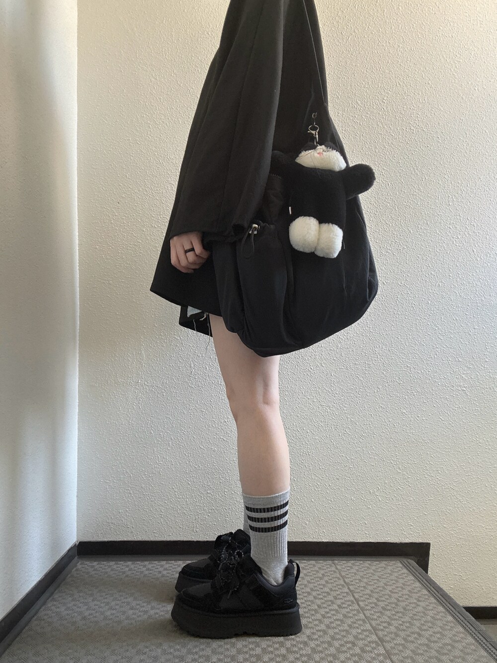 ブラック系のショルダーバッグ、ブラック系のスニーカーを着用したレディースの秋コーディネートの2枚目の写真