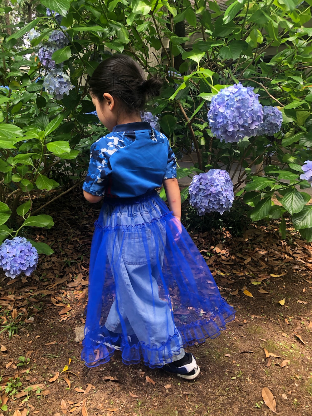 ブルー系のスカート、ブルー系のスニーカー、ブルー系のTシャツ/カットソーを着用したキッズの夏コーディネートの3枚目の写真