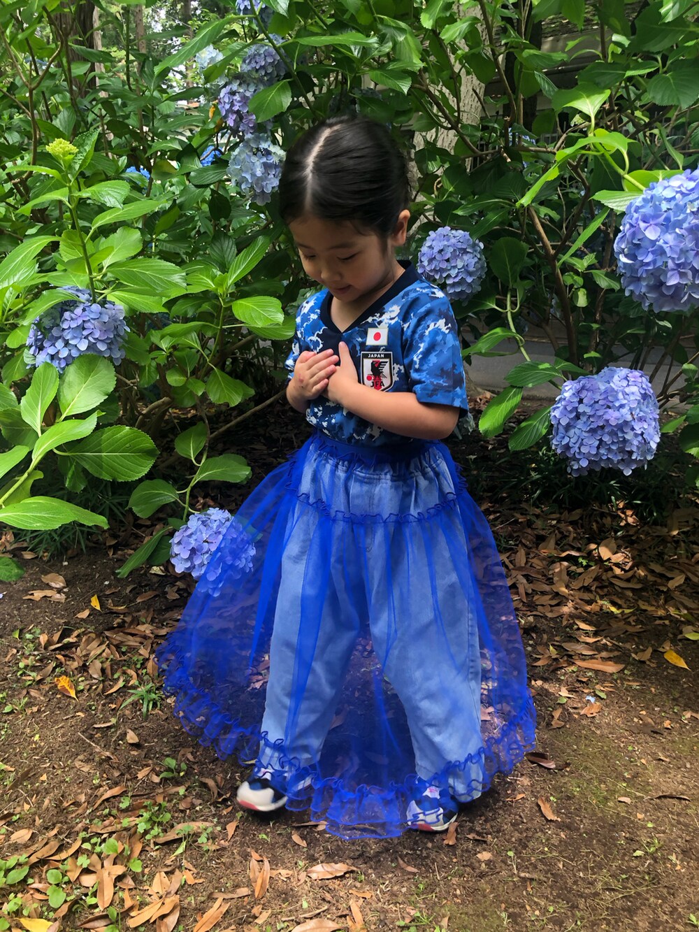 ブルー系のスカート、ブルー系のスニーカー、ブルー系のTシャツ/カットソーを着用したキッズの夏コーディネートの2枚目の写真