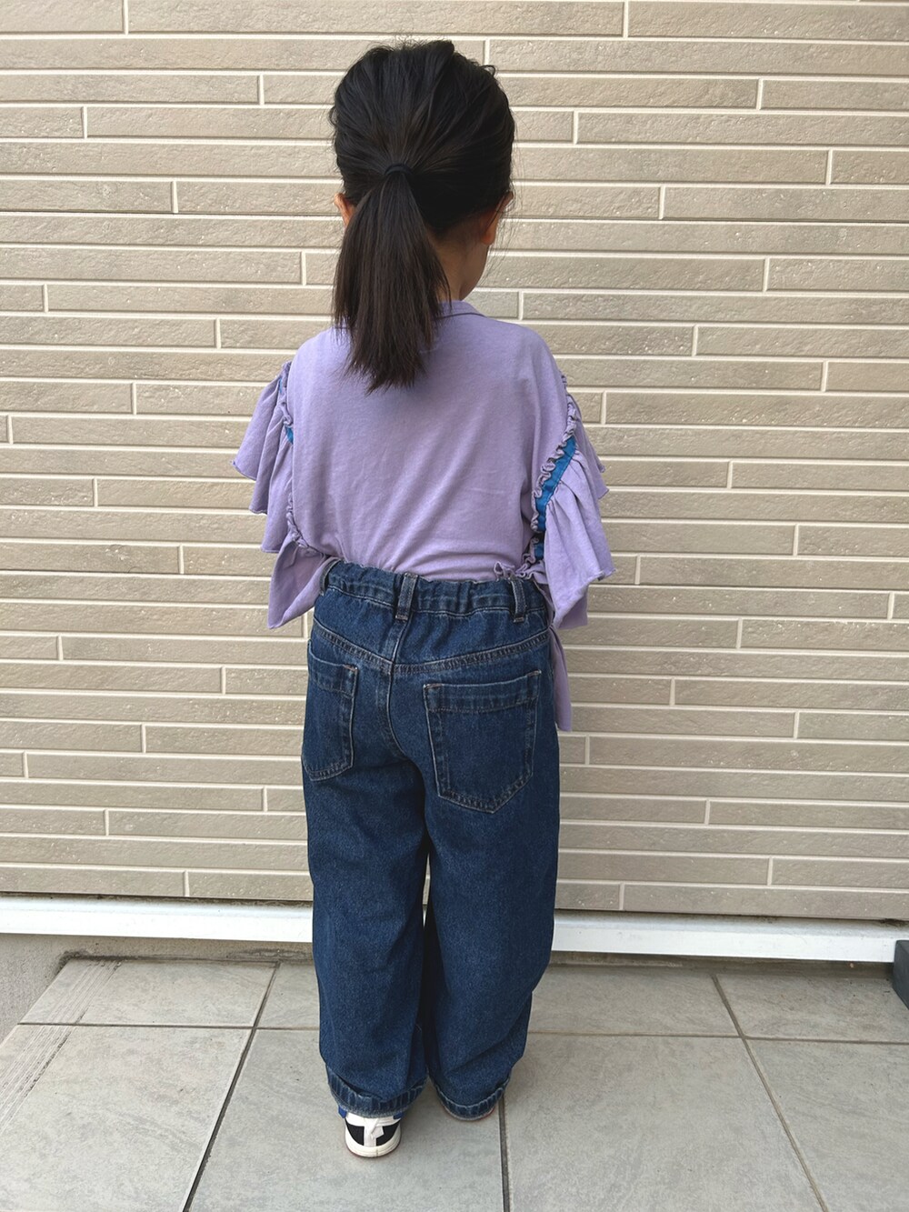 ブルー系のデニムパンツ、パープル系のTシャツ/カットソー、ブルー系のスニーカーを着用したキッズの夏コーディネートの3枚目の写真