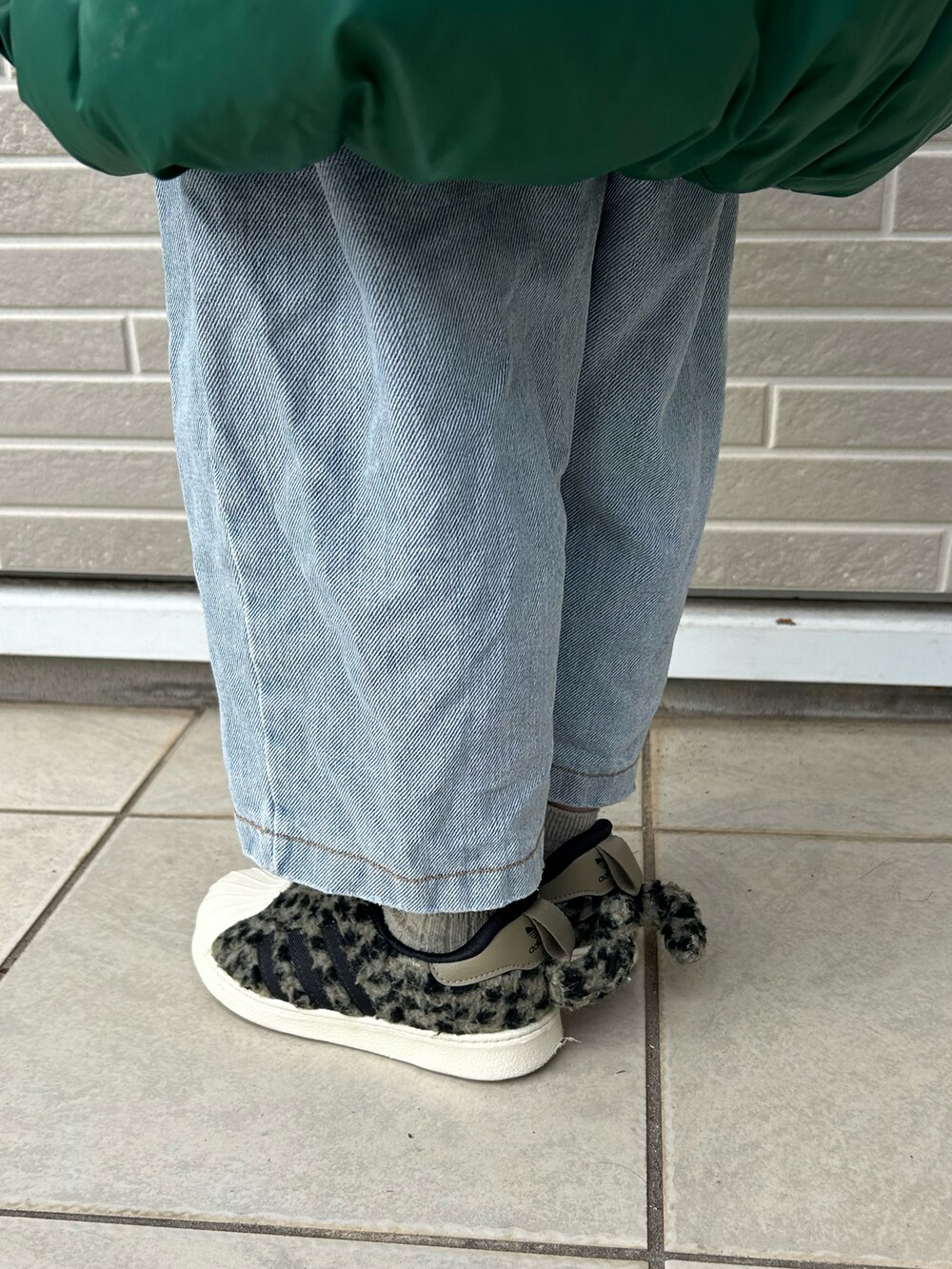 グリーン系のスニーカー、グリーン系のダウンベストを着用したキッズの冬コーディネートの4枚目の写真