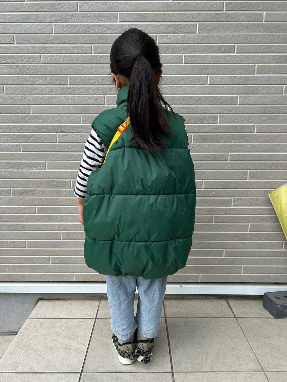 グリーン系のスニーカー、グリーン系のダウンベストを着用したキッズの冬コーディネートの3枚目の写真