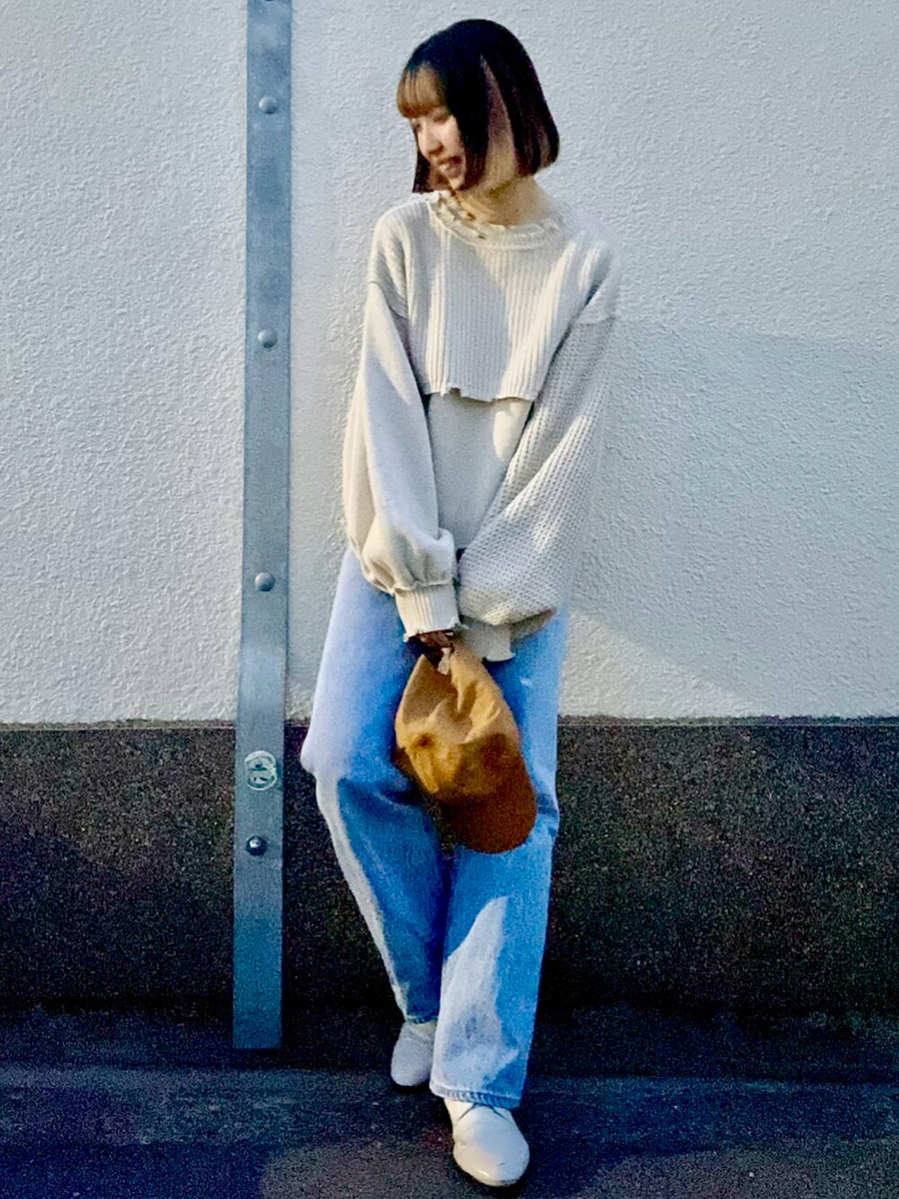 ベージュ系のニット/セーター、ブルー系のデニムパンツを着用したレディースの春コーディネートの2枚目の写真