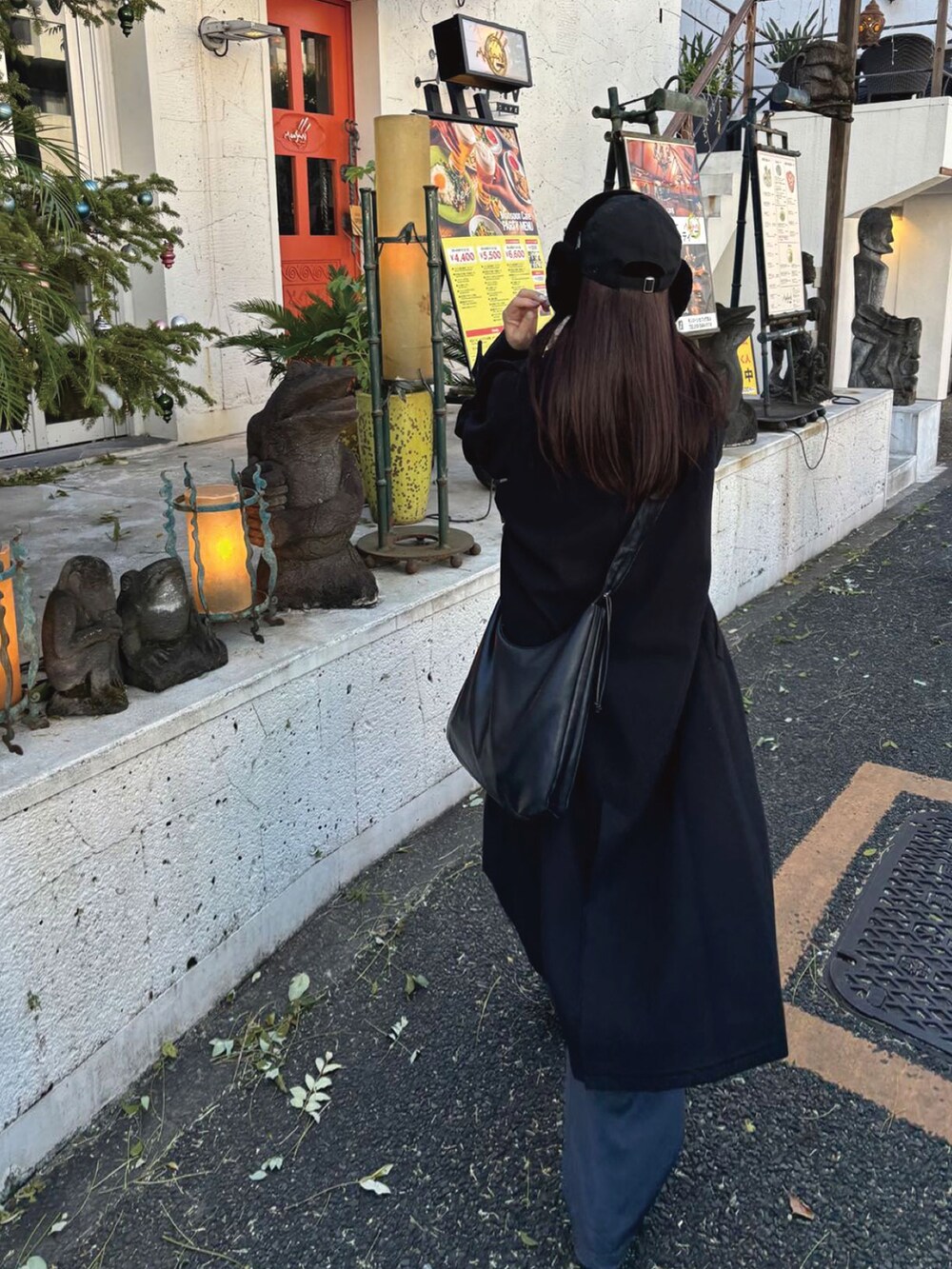 ブラック系のステンカラーコート、グレー系のニット/セーター、グレー系のカーゴパンツを着用したレディースの冬コーディネートの2枚目の写真