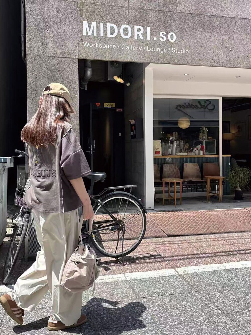 グレー系のTシャツ/カットソー、ホワイト系のチノパンツ、ベージュ系のショルダーバッグを着用したレディースの春コーディネートの3枚目の写真