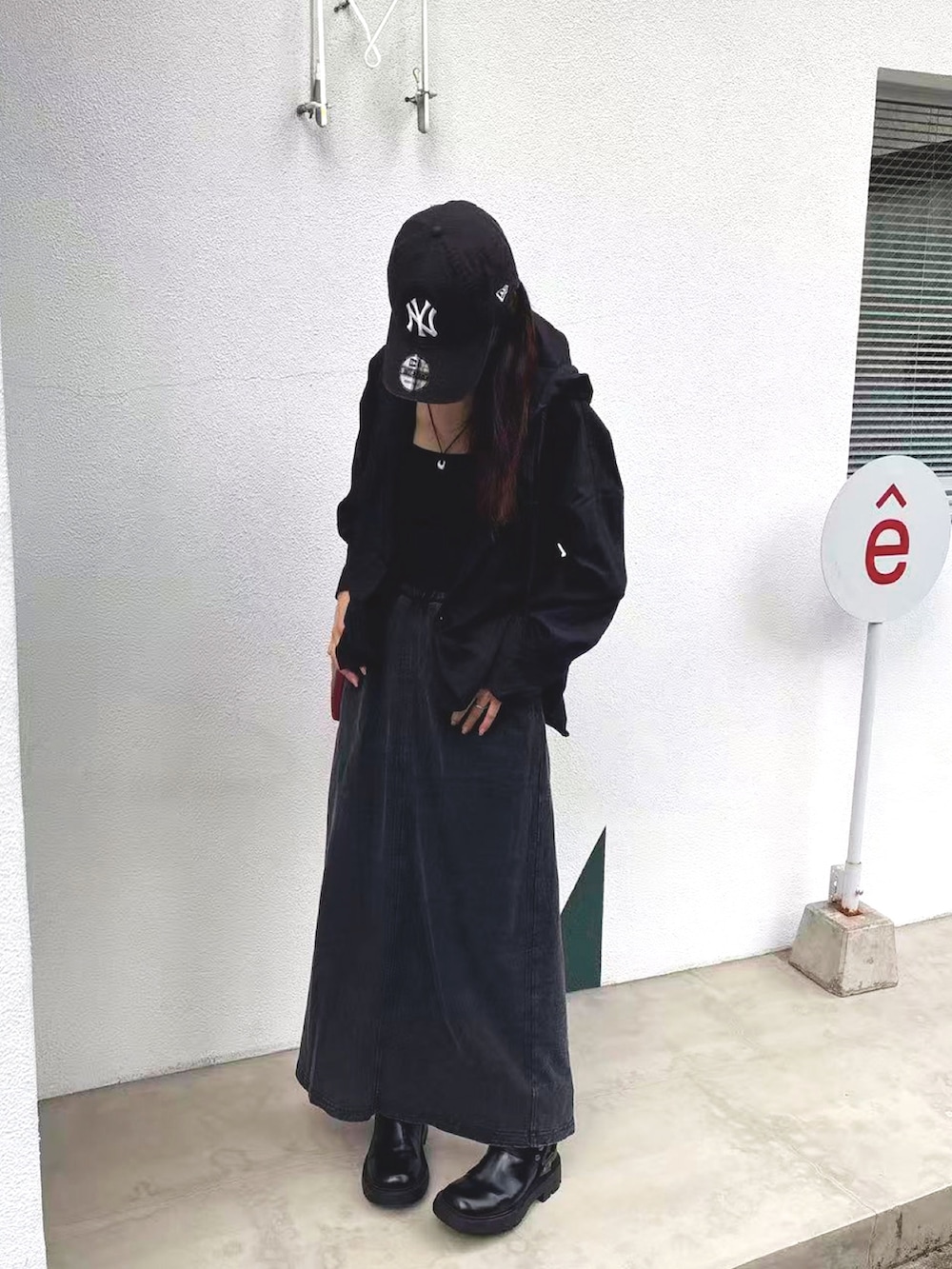 ブラック系のTシャツ/カットソー、レッド系のトートバッグ、ブラック系のスカートを着用したレディースの秋コーディネートの2枚目の写真