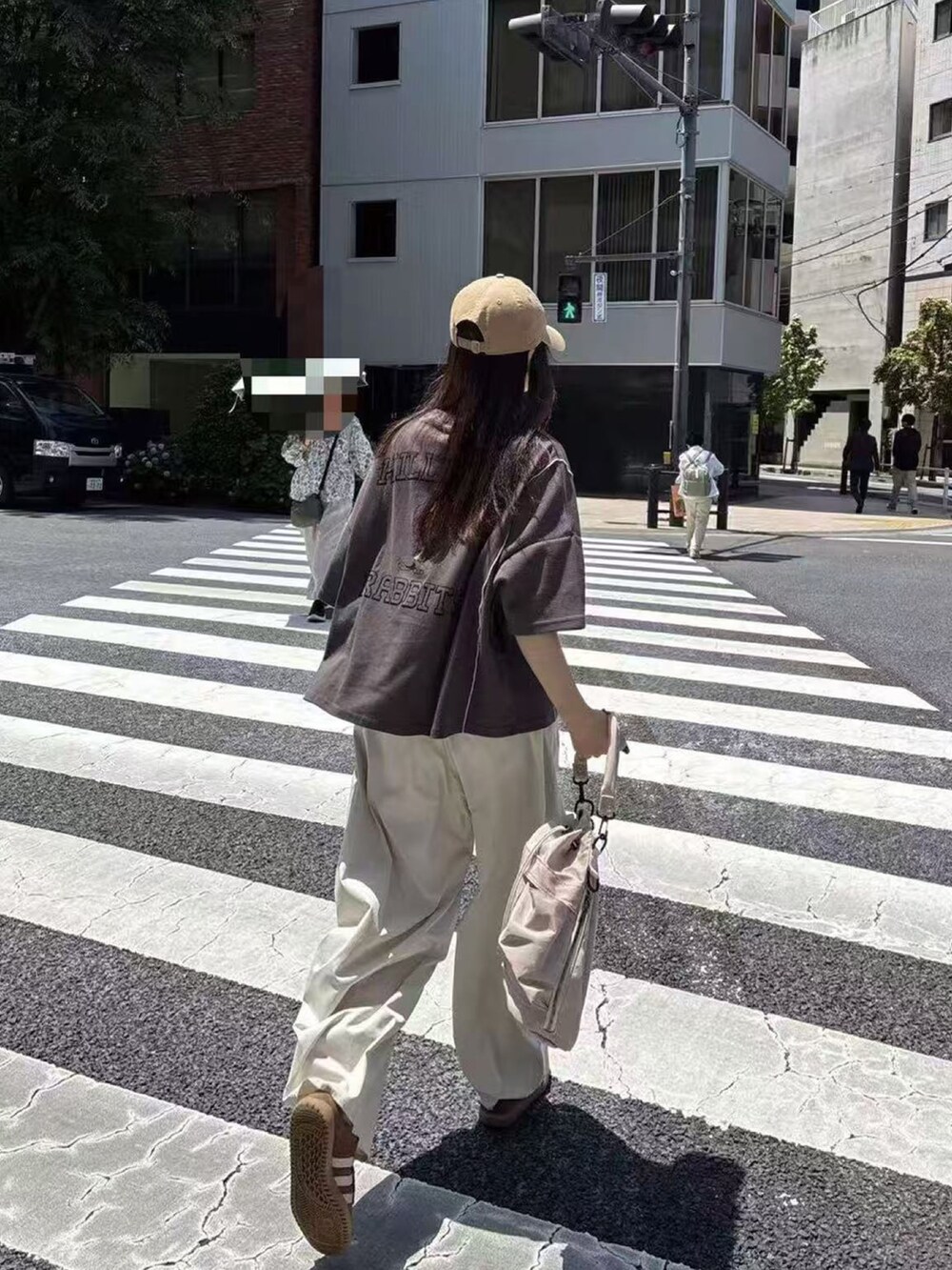 グレー系のTシャツ/カットソー、ホワイト系のチノパンツ、ベージュ系のショルダーバッグを着用したレディースの春コーディネートの2枚目の写真