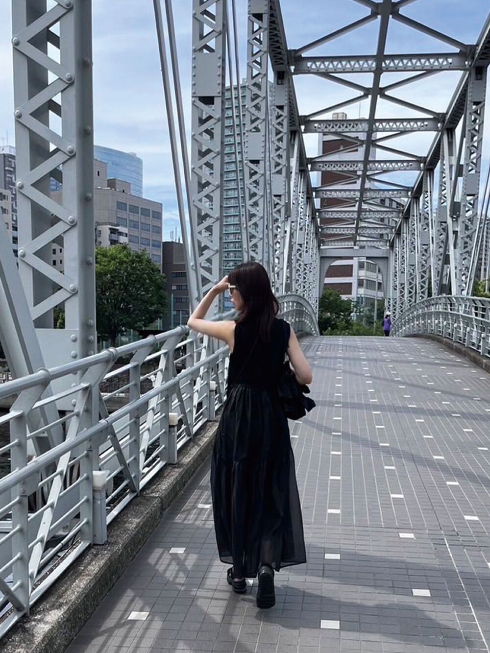 ブラック系のショルダーバッグ、ブラック系のワンピース、ブラック系のサンダルを着用したレディースの夏コーディネートの3枚目の写真