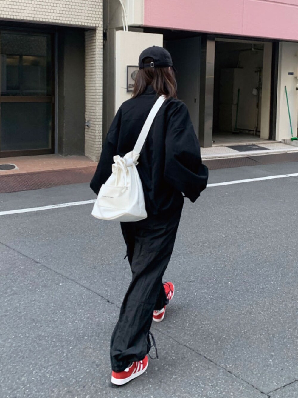 ブラック系のシャツ/ブラウス、ホワイト系のトートバッグ、レッド系のスニーカーを着用したレディースの春コーディネートの3枚目の写真