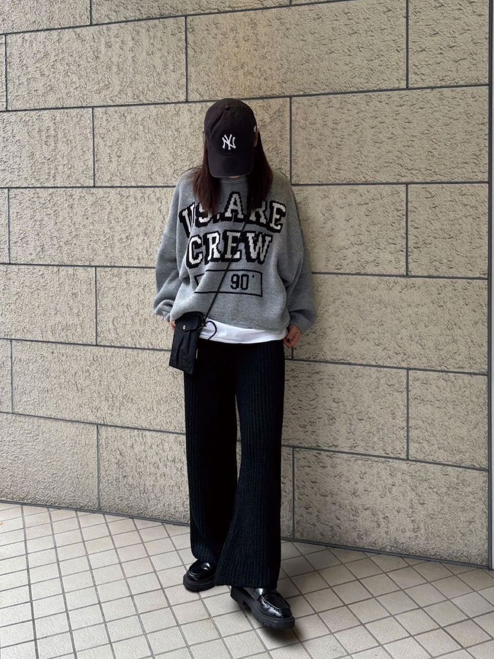 グレー系のニット/セーター、ブラック系のその他パンツ、ホワイト系のTシャツ/カットソーを着用したレディースの秋コーディネートの2枚目の写真