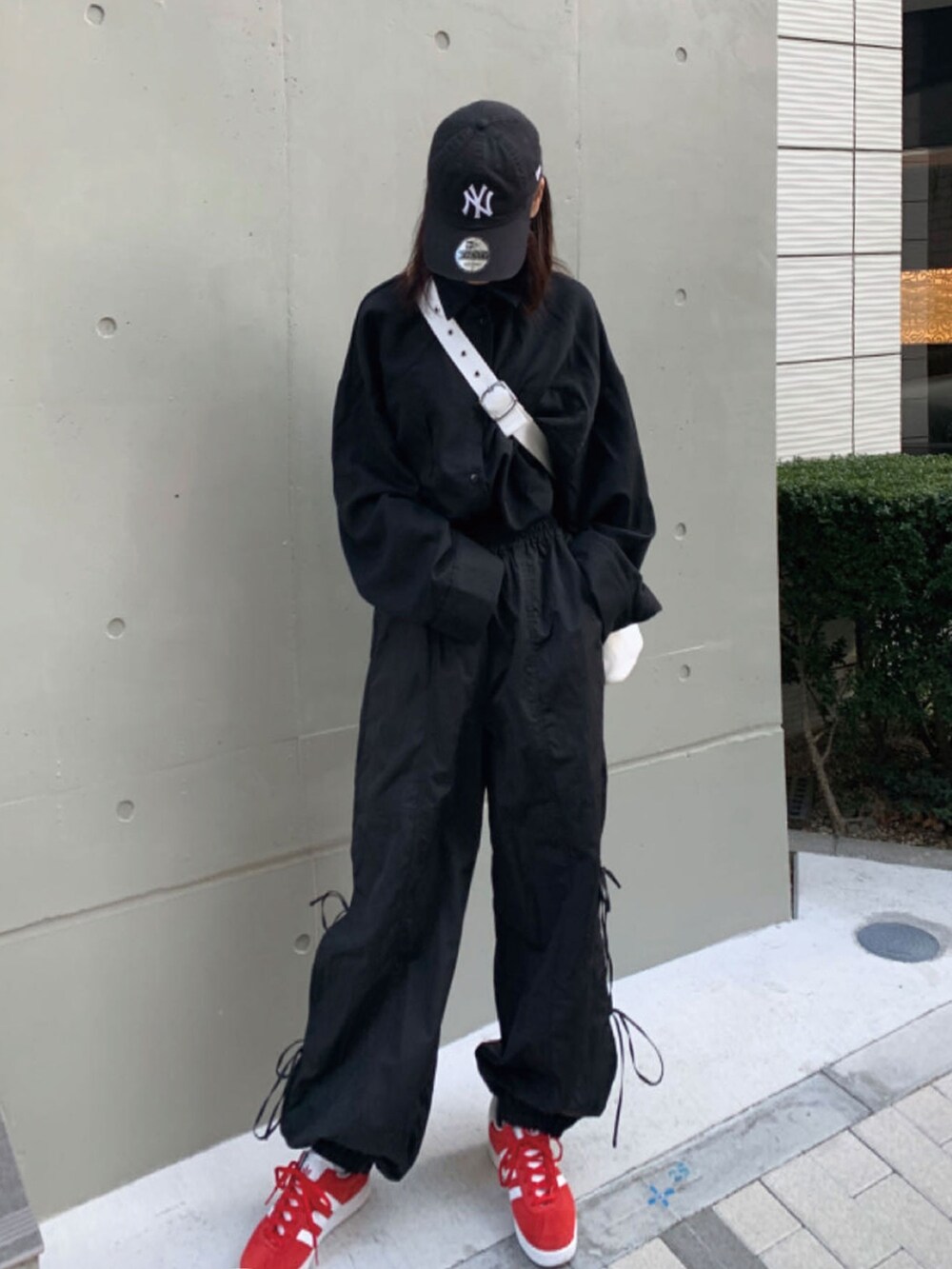 ブラック系のシャツ/ブラウス、ホワイト系のトートバッグ、レッド系のスニーカーを着用したレディースの春コーディネートの2枚目の写真
