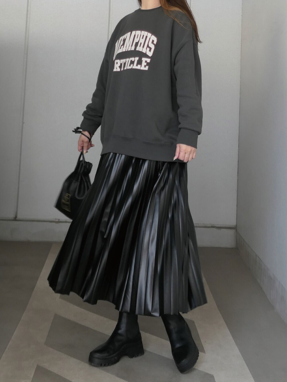 ブラック系のスウェット、ホワイト系のTシャツ/カットソー、ブラック系のスカートを着用したレディースの秋コーディネートの2枚目の写真