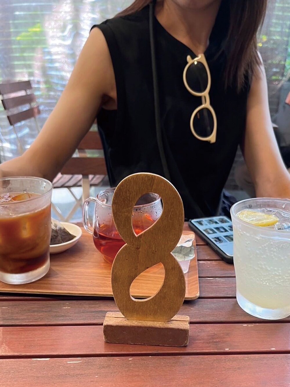 ブラック系のショルダーバッグ、ブラック系のワンピース、ブラック系のサンダルを着用したレディースの夏コーディネートの4枚目の写真