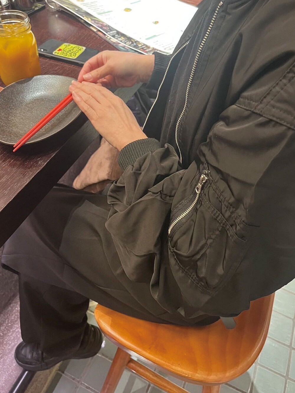 ブラック系のMA-1、ブラック系のスニーカー、ブラック系のショルダーバッグを着用したレディースの冬コーディネートの2枚目の写真