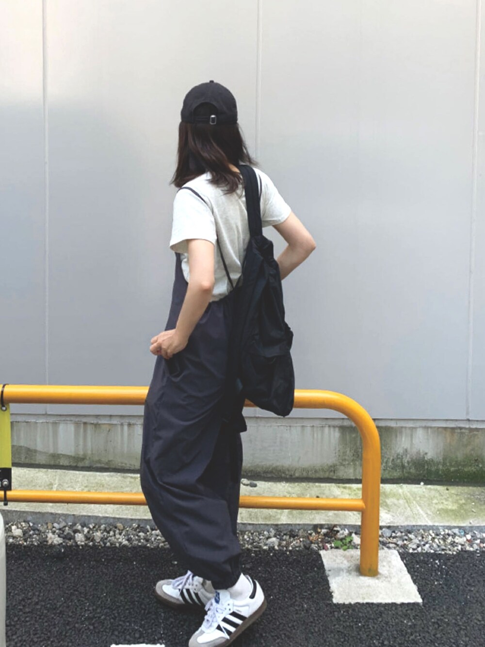 ホワイト系のTシャツ/カットソー、ブラック系のバックパック/リュック、ホワイト系のスニーカーを着用したレディースの春コーディネートの2枚目の写真