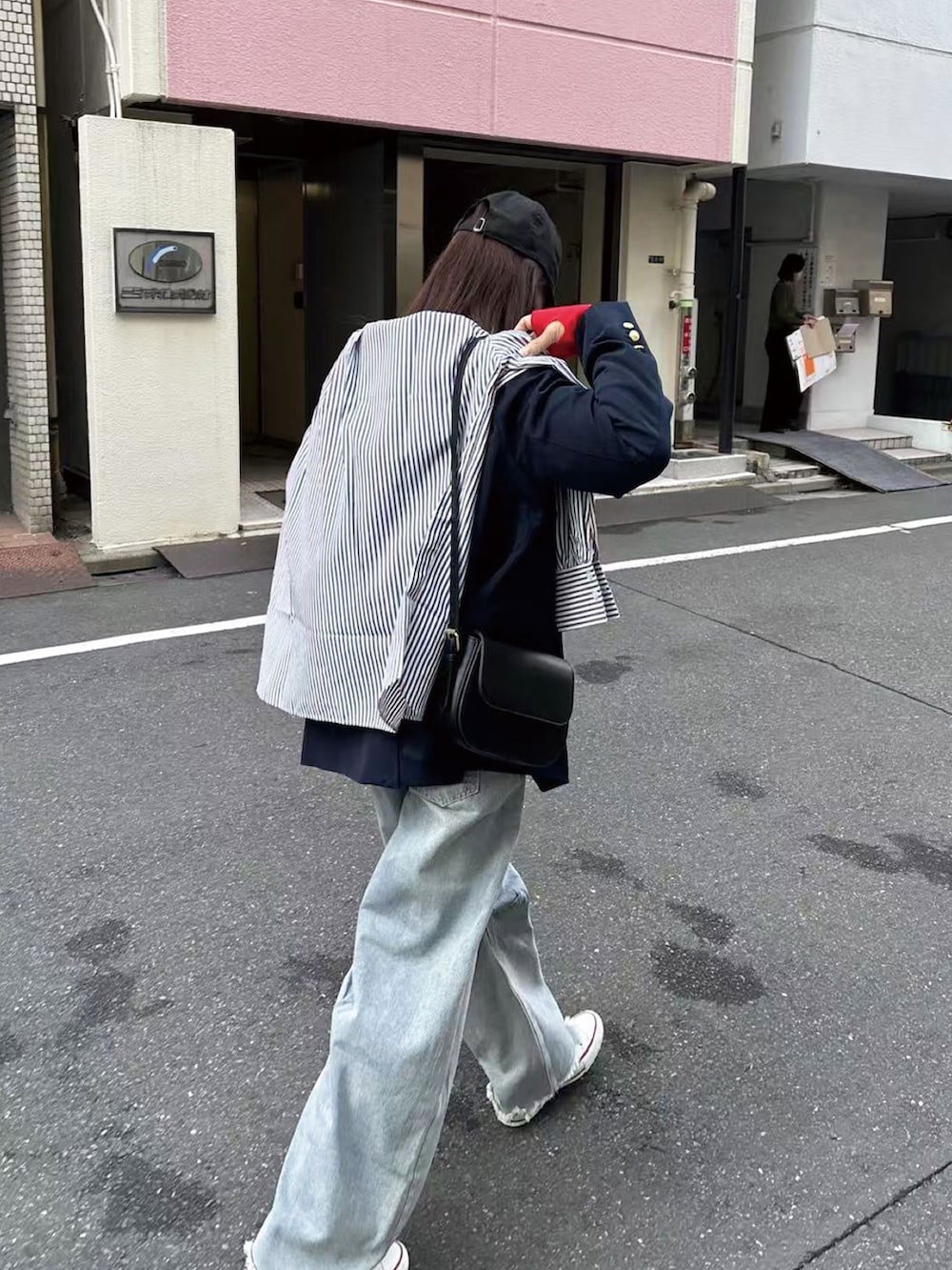 ブルー系のテーラードジャケット、レッド系のニット/セーター、ブラック系のショルダーバッグを着用したレディースの冬コーディネートの2枚目の写真