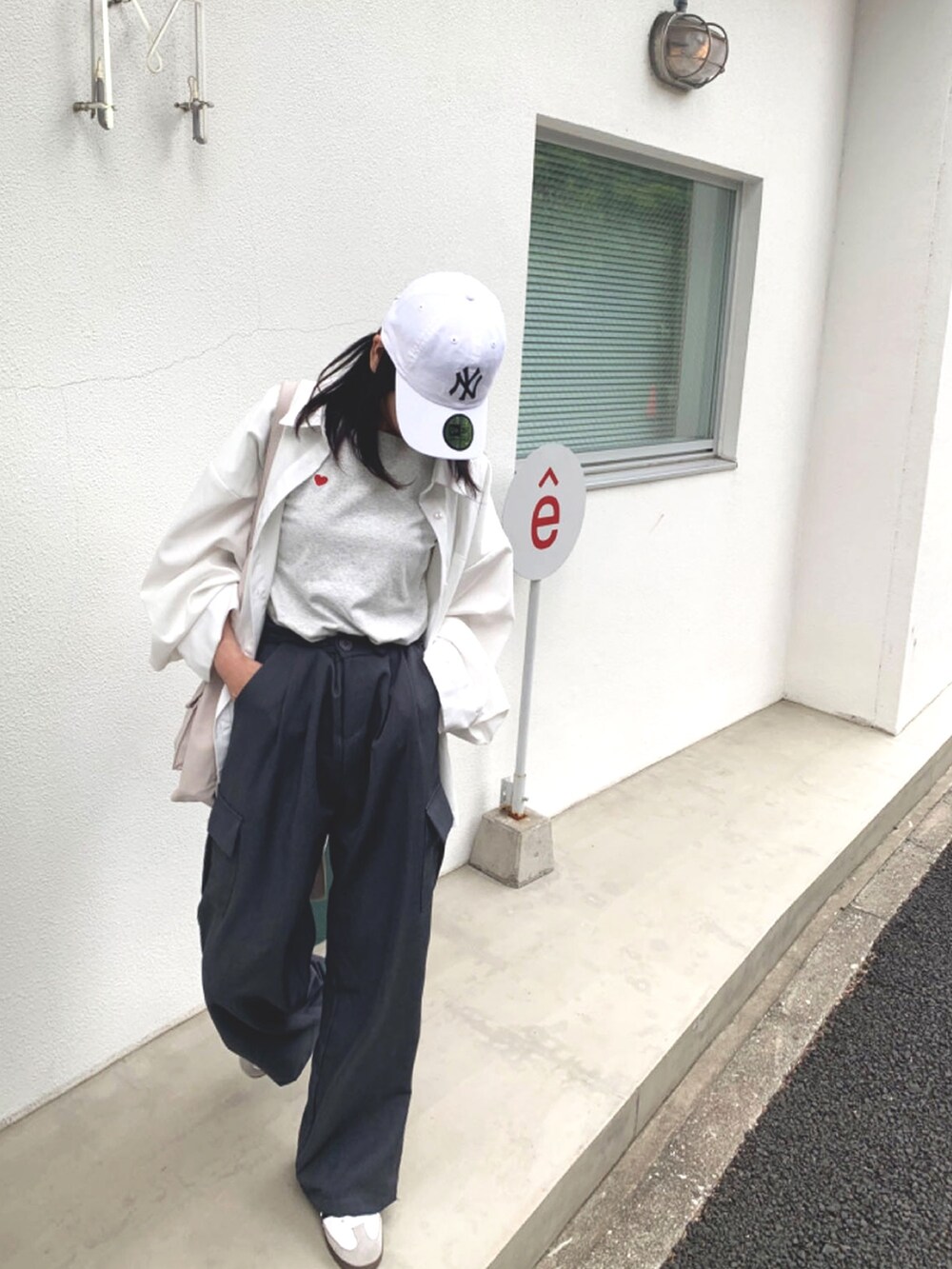 ホワイト系のシャツ/ブラウス、ベージュ系のバックパック/リュック、グレー系のカーゴパンツを着用したレディースの春コーディネートの2枚目の写真