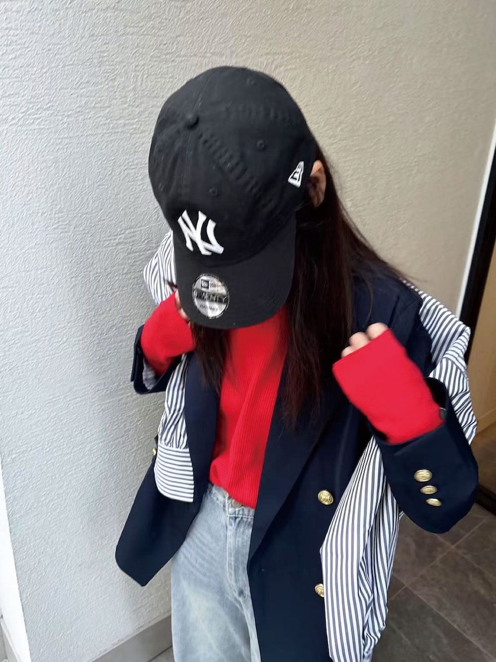 ブルー系のテーラードジャケット、レッド系のニット/セーター、ブラック系のショルダーバッグを着用したレディースの冬コーディネートの3枚目の写真