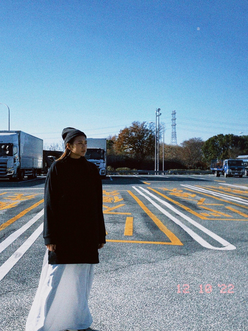 ブラック系のトップス、ホワイト系のワンピース/ドレスを着用したレディースの春コーディネートの2枚目の写真