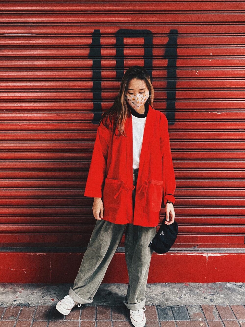 ベージュ系のパンツ、ブラック系のバッグ、レッド系のジャケット/アウターを着用したレディースの春コーディネートの3枚目の写真