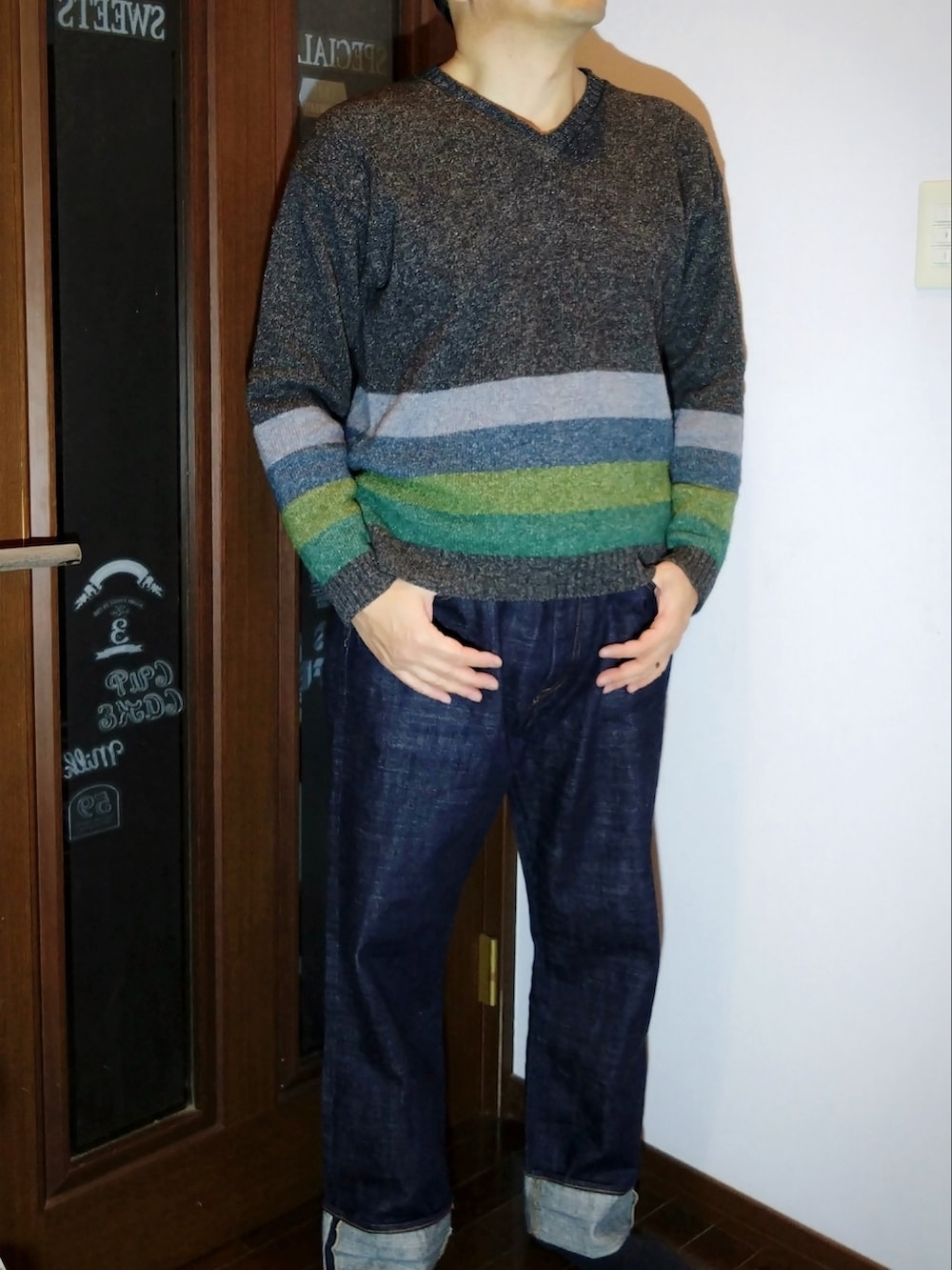 ブルー系のデニムパンツ、グレー系のニット/セーター、ブラック系のダウンジャケット/コートを着用したメンズの冬コーディネートの3枚目の写真