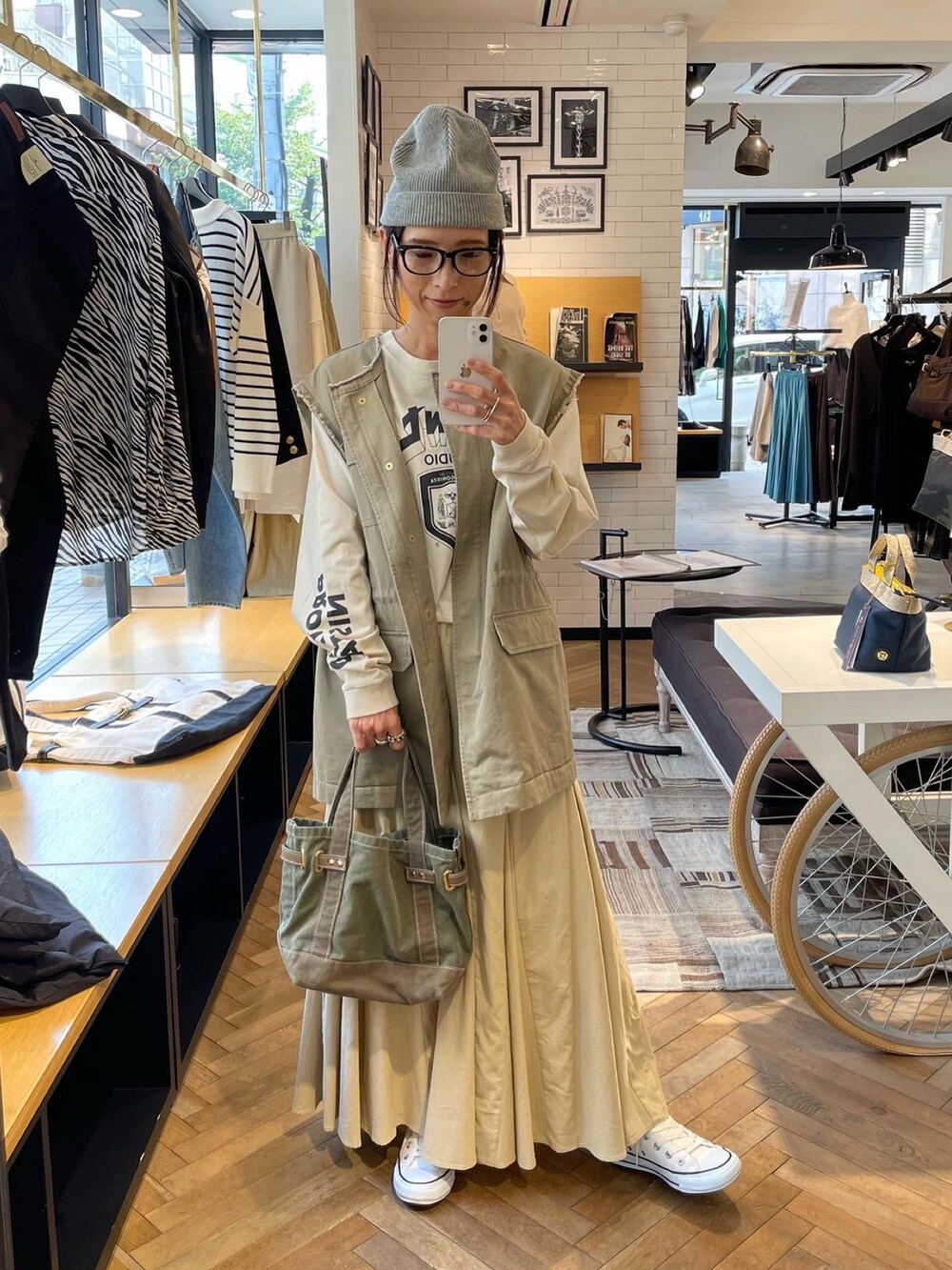 ベージュ系のTシャツ/カットソー、ベージュ系のミリタリージャケット、ベージュ系のスカートを着用したレディースの秋コーディネートの3枚目の写真