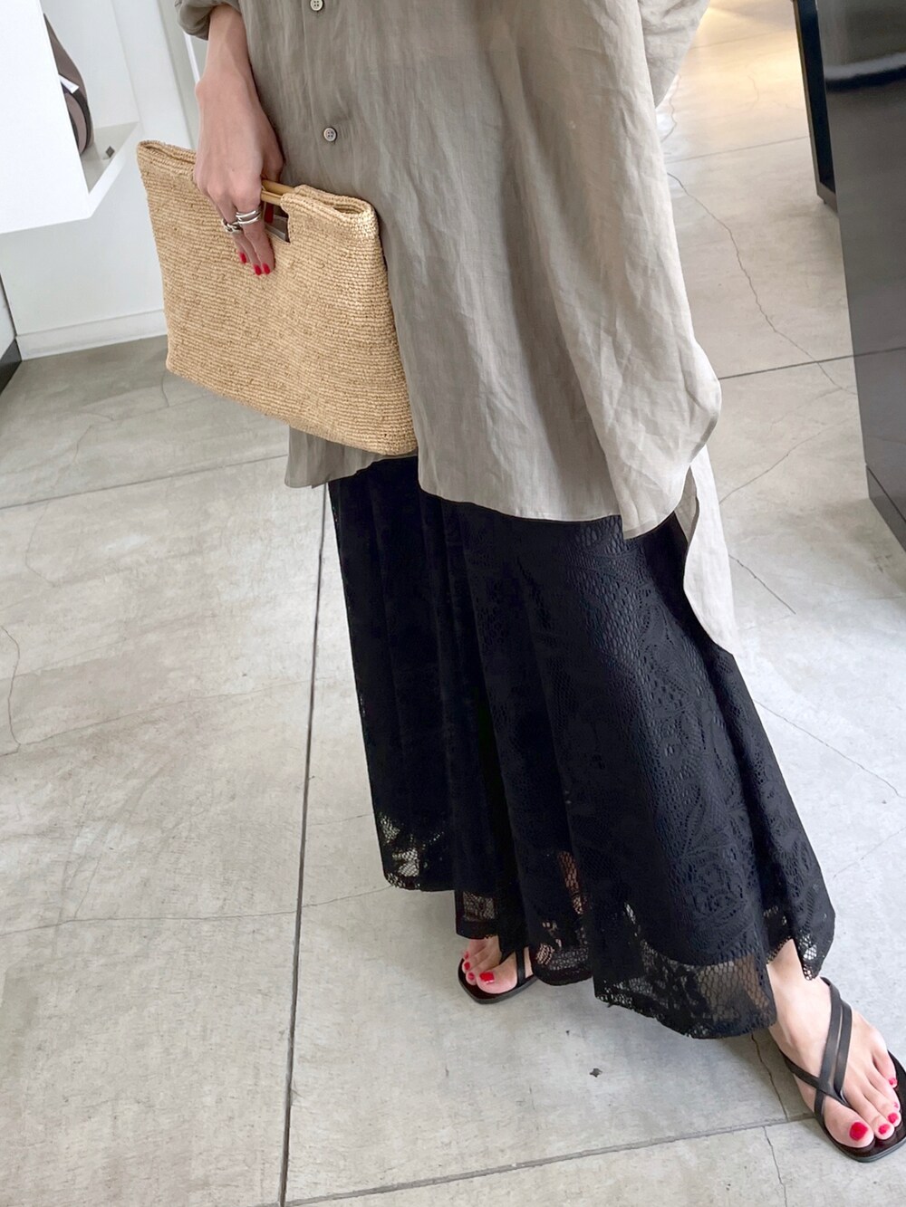 グリーン系のシャツ/ブラウス、ブラウン系のクラッチバッグ、ホワイト系のスカートを着用したレディースの夏コーディネートの3枚目の写真