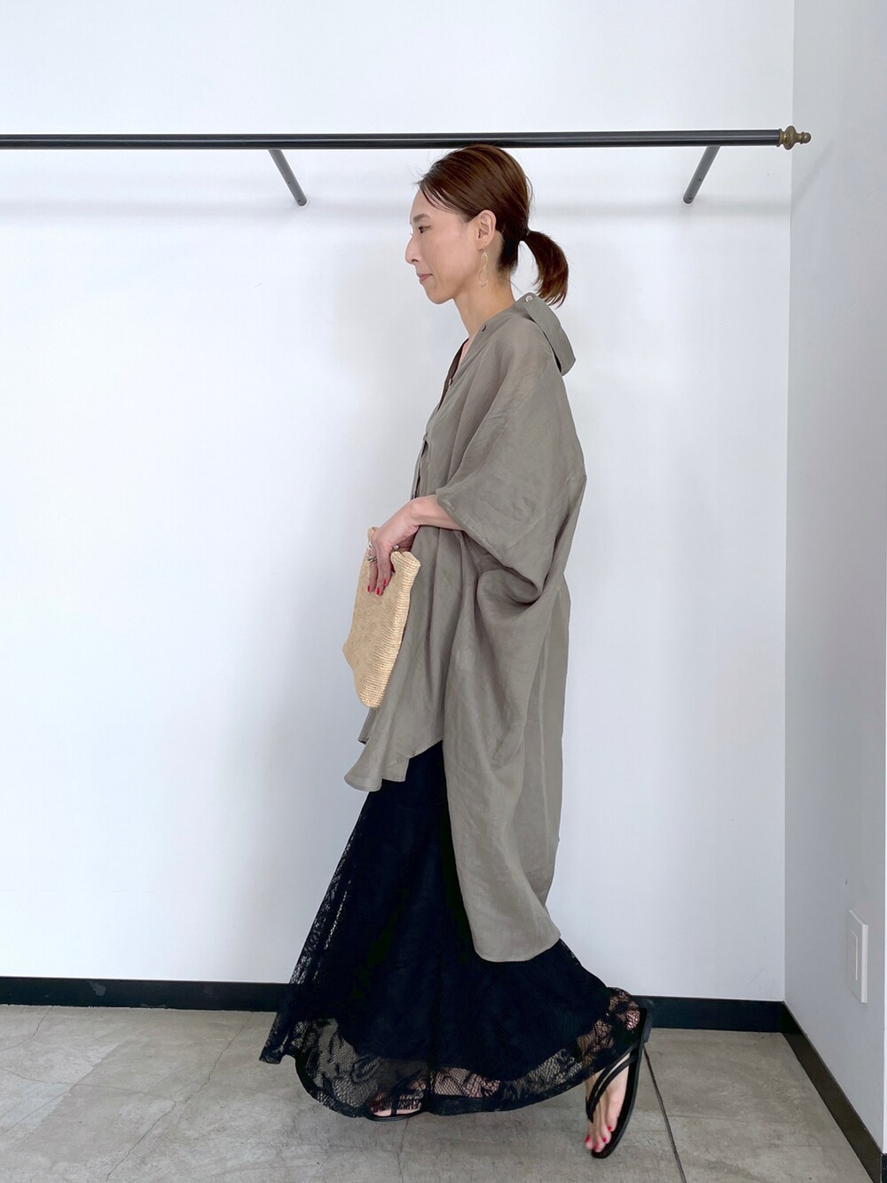 グリーン系のシャツ/ブラウス、ブラウン系のクラッチバッグ、ホワイト系のスカートを着用したレディースの夏コーディネートの2枚目の写真