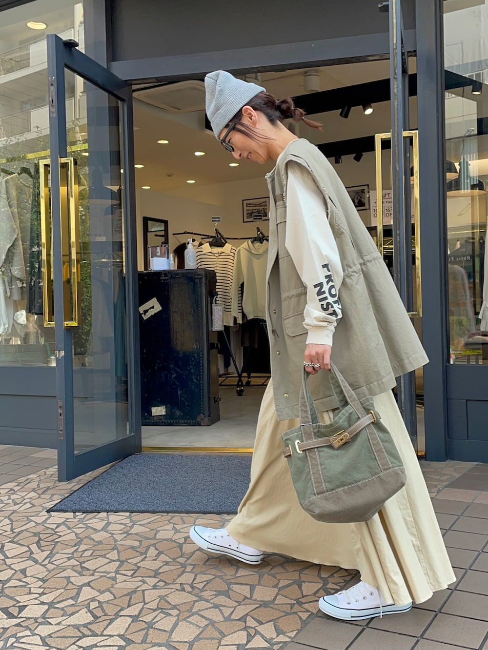 ベージュ系のTシャツ/カットソー、ベージュ系のミリタリージャケット、ベージュ系のスカートを着用したレディースの秋コーディネートの4枚目の写真