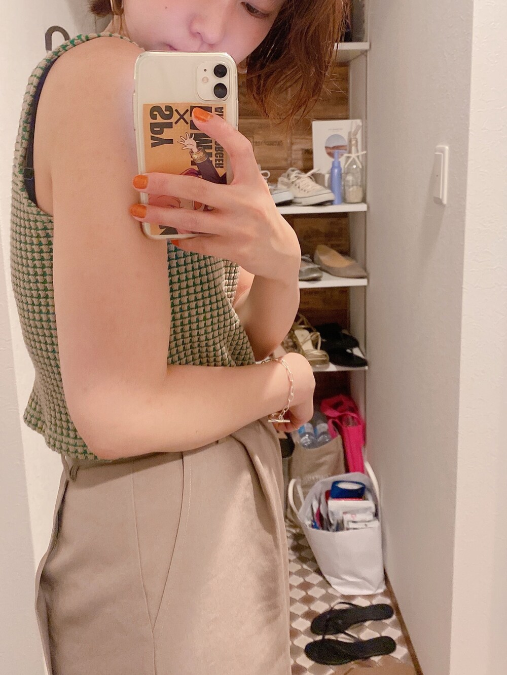 ベージュ系のパンツ、ベージュ系のタンクトップ、ブラック系のサンダルを着用したレディースの夏コーディネートの2枚目の写真